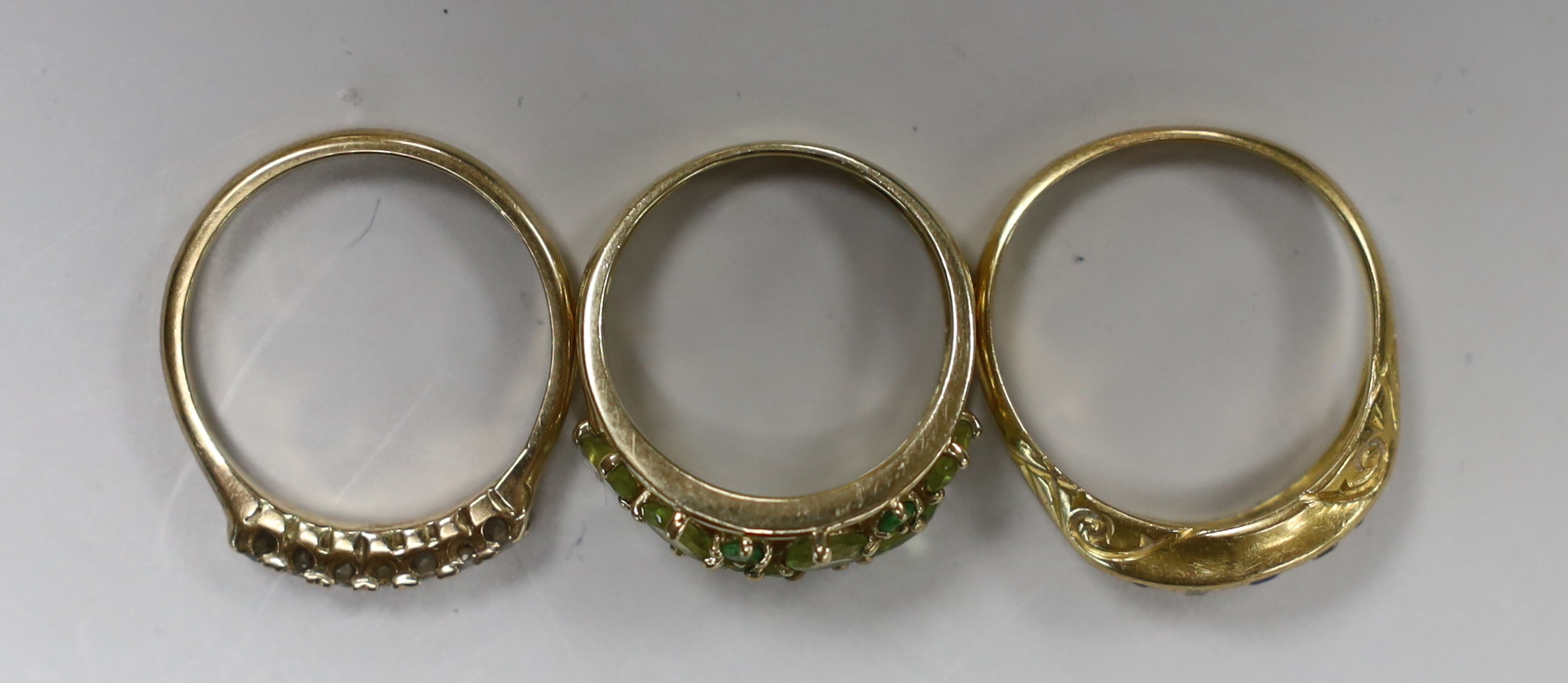 A George V 18ct gold, sapphire and diamond chip set half hoop ring, size Q, gross weight 3.7 grams and two 9ct and gem set rings, gross weight 5 grams.